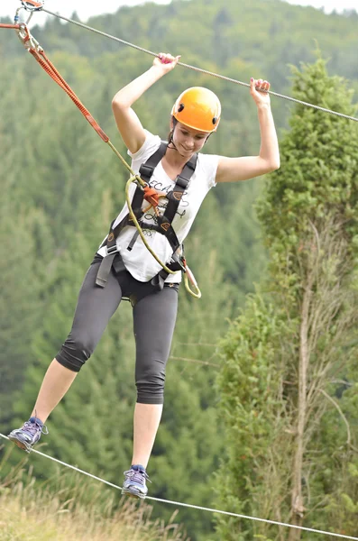 Ragazza felice arrampicata tra gli alberi — Foto Stock