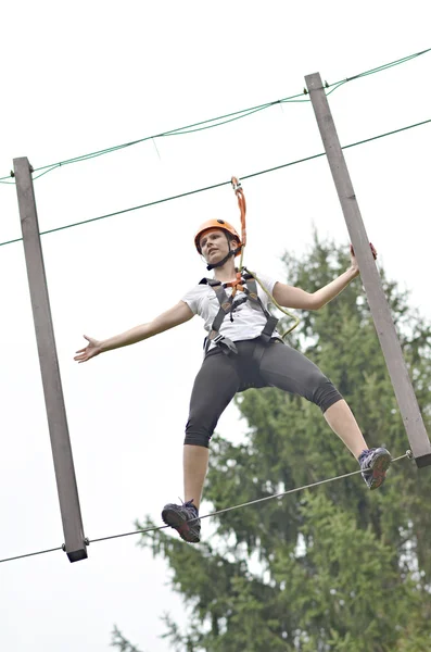 Happy girl climbing between trees — Stock Photo, Image