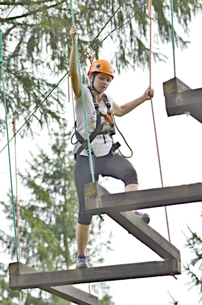 Happy girl climbing between trees — Stock Photo, Image