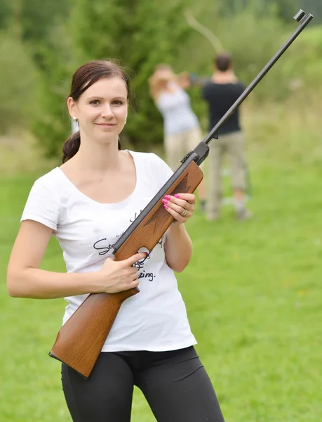 Chica apuntando un rifle neumático — Foto de Stock