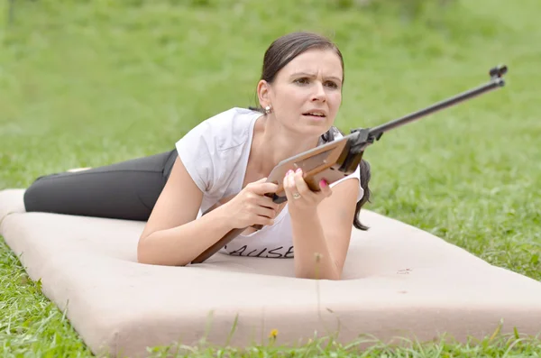 Chica apuntando un rifle neumático — Foto de Stock