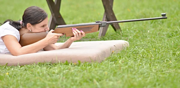 Menina apontando um rifle pneumático — Fotografia de Stock