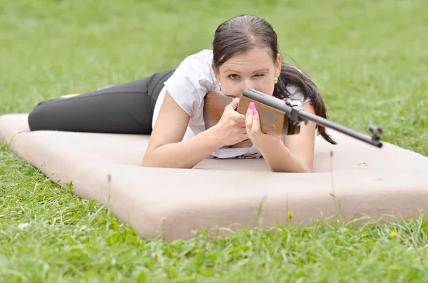 Ragazza che punta un fucile pneumatico — Foto Stock