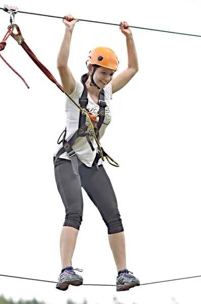 Menina feliz escalando entre árvores — Fotografia de Stock