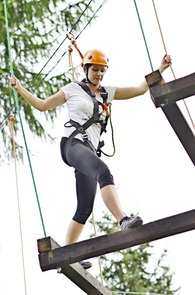 Happy girl climbing between trees — Stock Photo, Image