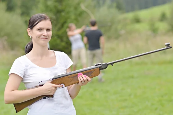 Chica apuntando un rifle neumático — Foto de Stock