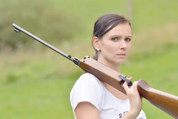 Menina apontando um rifle pneumático — Fotografia de Stock