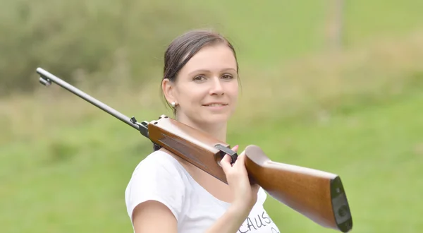 Chica apuntando un rifle neumático — Foto de Stock