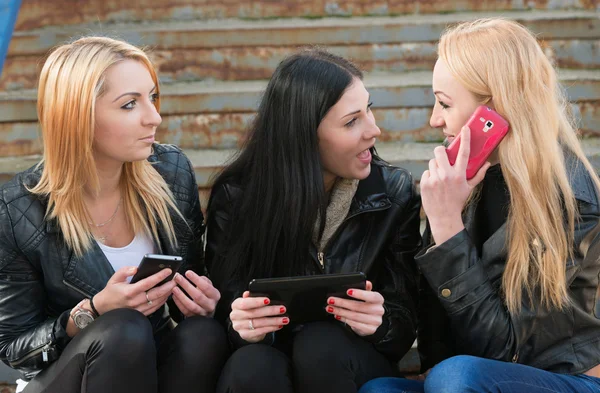 Meninas usando tablet digital e telefones celulares — Fotografia de Stock