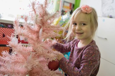 Noel ağacı süsleyen küçük kız