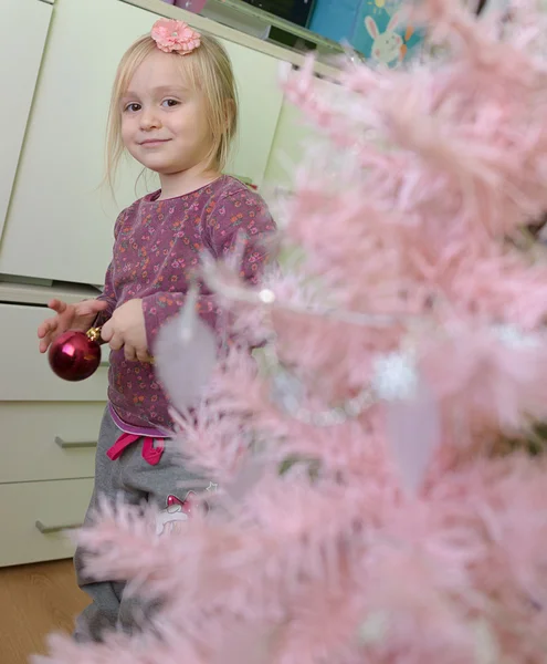 Holčička zdobí vánoční stromeček — Stock fotografie