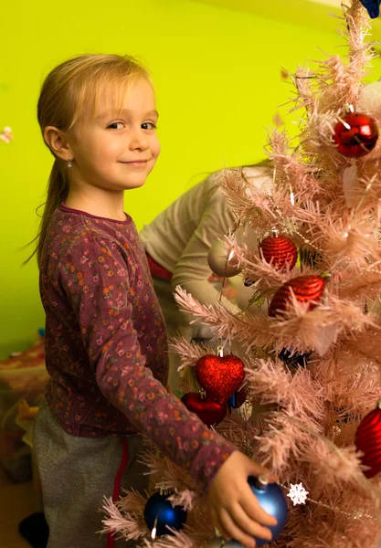 Noel ağacı süsleyen küçük kız — Stok fotoğraf