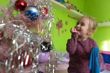 Noel ağacı süsleyen küçük kız