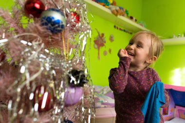 Noel ağacı süsleyen küçük kız