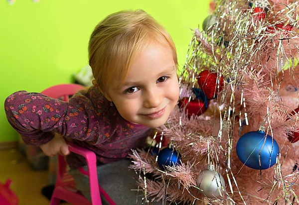 Holčička zdobí vánoční stromeček — Stock fotografie