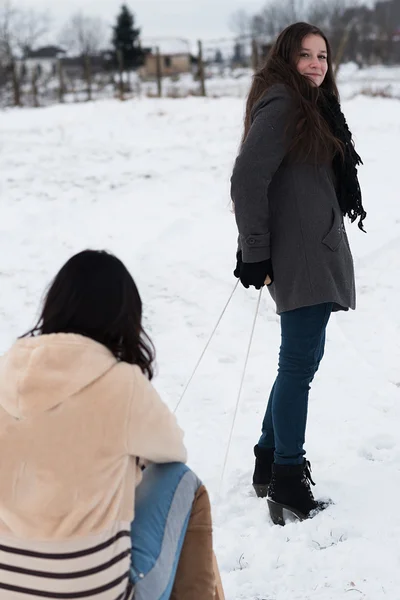 Zwei Freundinnen rodeln bergab — Stockfoto