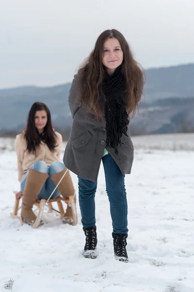 Two girlfriends sledge downhill — Stock Photo, Image