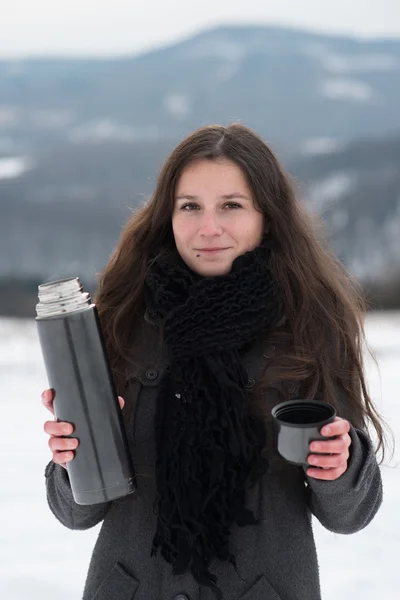Девушка пьет горячий чай зимой — стоковое фото