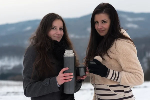 Dos amigas con té caliente o café al aire libre —  Fotos de Stock