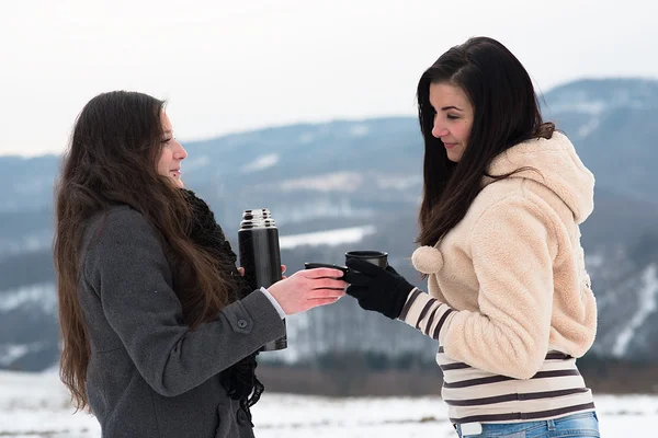 Two girlfriends with hot tea or coffee outdoors — Stock Photo, Image