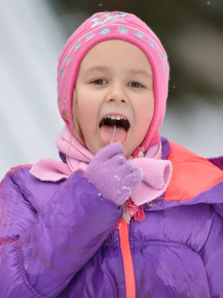 Girl licking the icicle — Stock Photo, Image