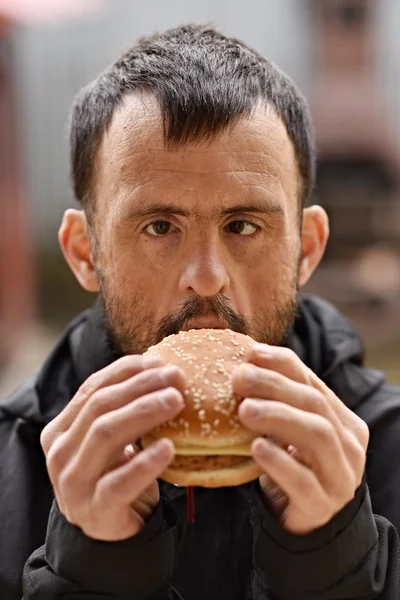 Uomo mangiare un hamburger — Foto Stock