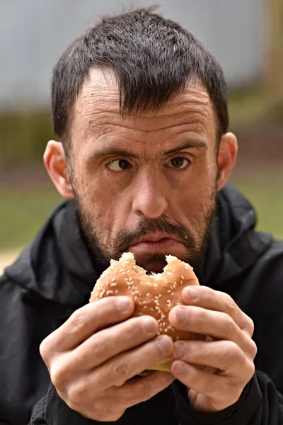 Mann isst einen Hamburger — Stockfoto