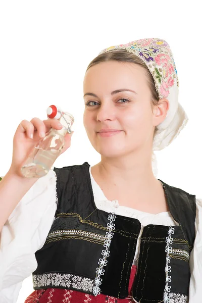 Mulher em trajes folclóricos eslovacos com garrafa de álcool — Fotografia de Stock