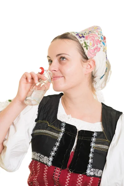 Žena v slovenském kroj s lahví alkoholu — Stock fotografie