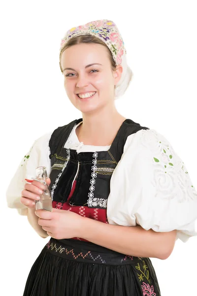 Vrouw in Slowaakse folk kostuum met fles alcohol — Stockfoto