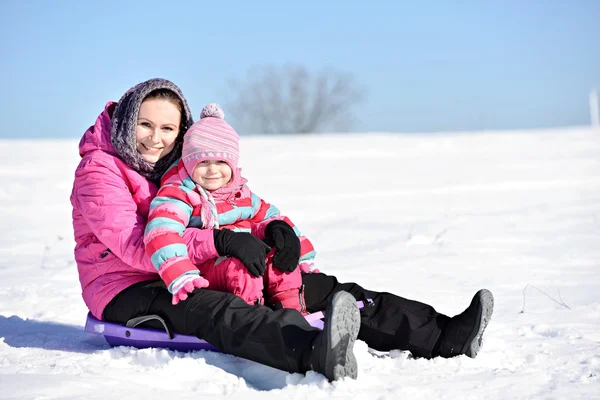 母亲和女儿在雪橇上 — 图库照片