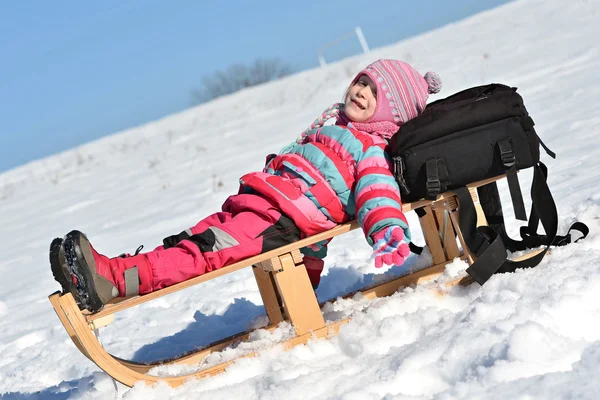 Meisje, zittend op een slee — Stockfoto