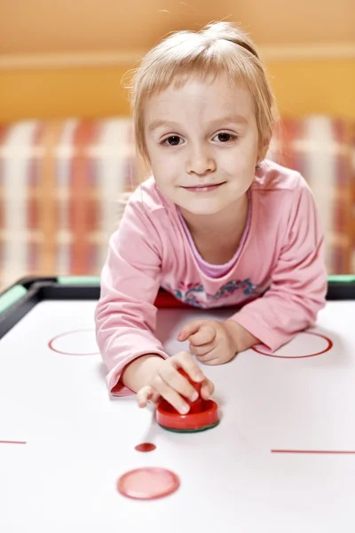 Little girl plays air hockey — Stock Photo, Image