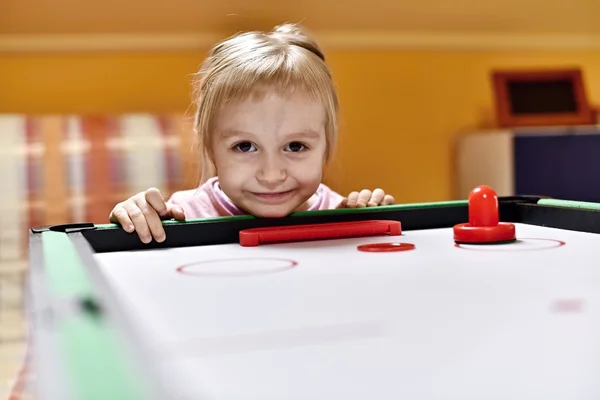 Little girl plays air hockey — Stock Photo, Image