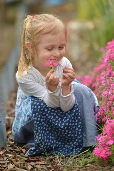 Маленька дівчинка в саду з квітами — стокове фото