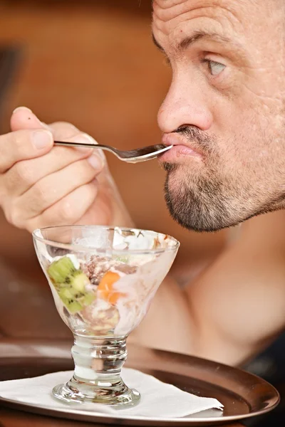 Man eating fruit desert — Stock Photo, Image
