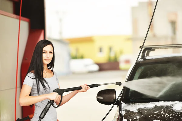 Kadın arabayı yıkıyor. — Stok fotoğraf