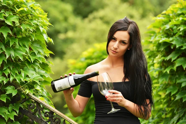 Ragazza in giardino con vino — Foto Stock