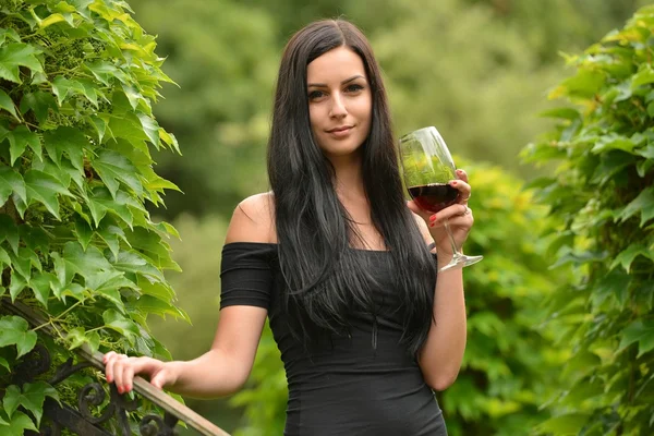 Girl in garden with wine — Stock Photo, Image