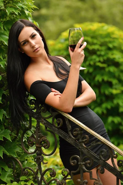 Meisje in de tuin met wijn — Stockfoto