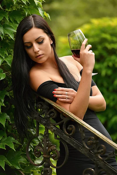 Ragazza in giardino con vino — Foto Stock