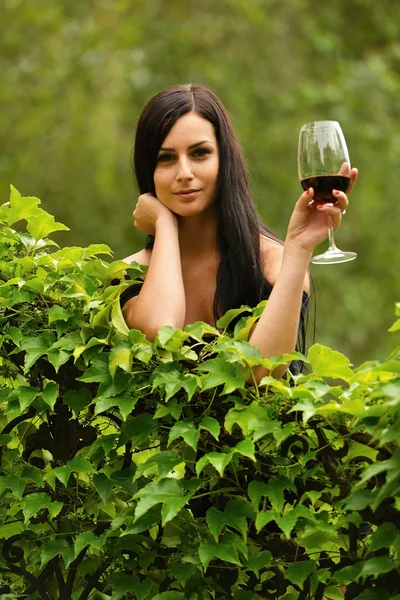 Ragazza in giardino con vino — Foto Stock