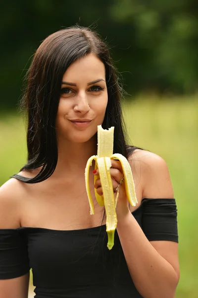 Girl in garden with banana — Stock Photo, Image