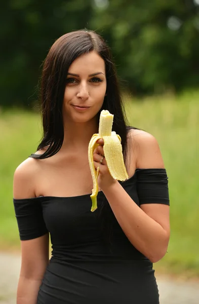 Meisje in de tuin met banaan — Stockfoto