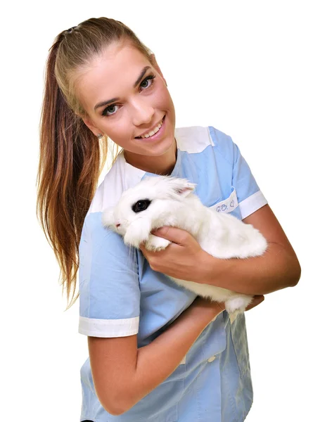 Sonriente veterinario sosteniendo y examinando lindo conejo blanco — Foto de Stock