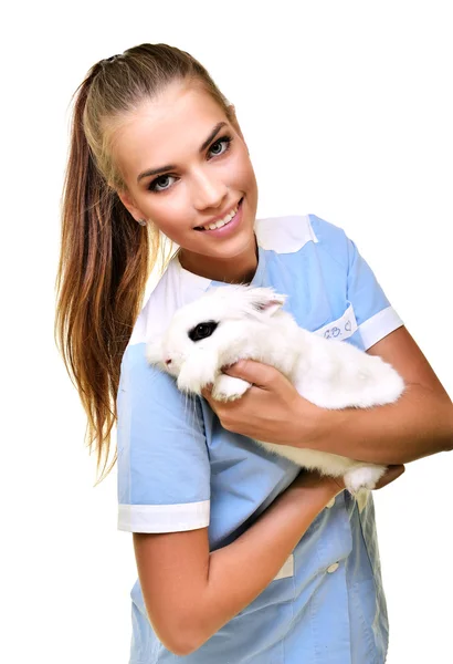 Sonriente veterinario sosteniendo y examinando lindo conejo blanco —  Fotos de Stock