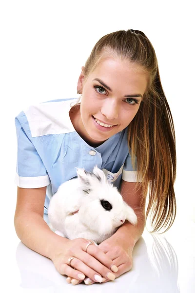 Veterinário sorrindo segurando e examinando coelho branco bonito — Fotografia de Stock