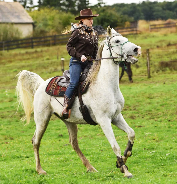 Cowgirl w wyścigu baryłkę na rodeo. — Zdjęcie stockowe