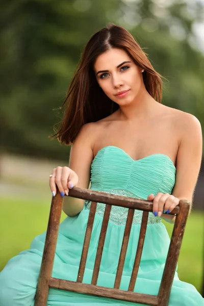 Young girl posing with chair — Stock Photo, Image