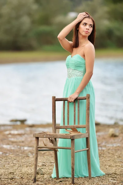 Ung flicka poserar med stol — Stockfoto